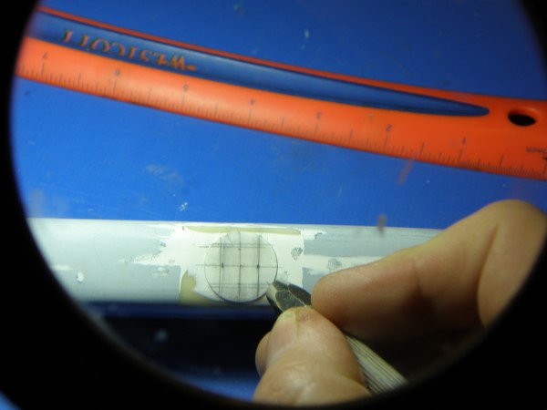Using a needle vice to detail the thin plastic disk patch.